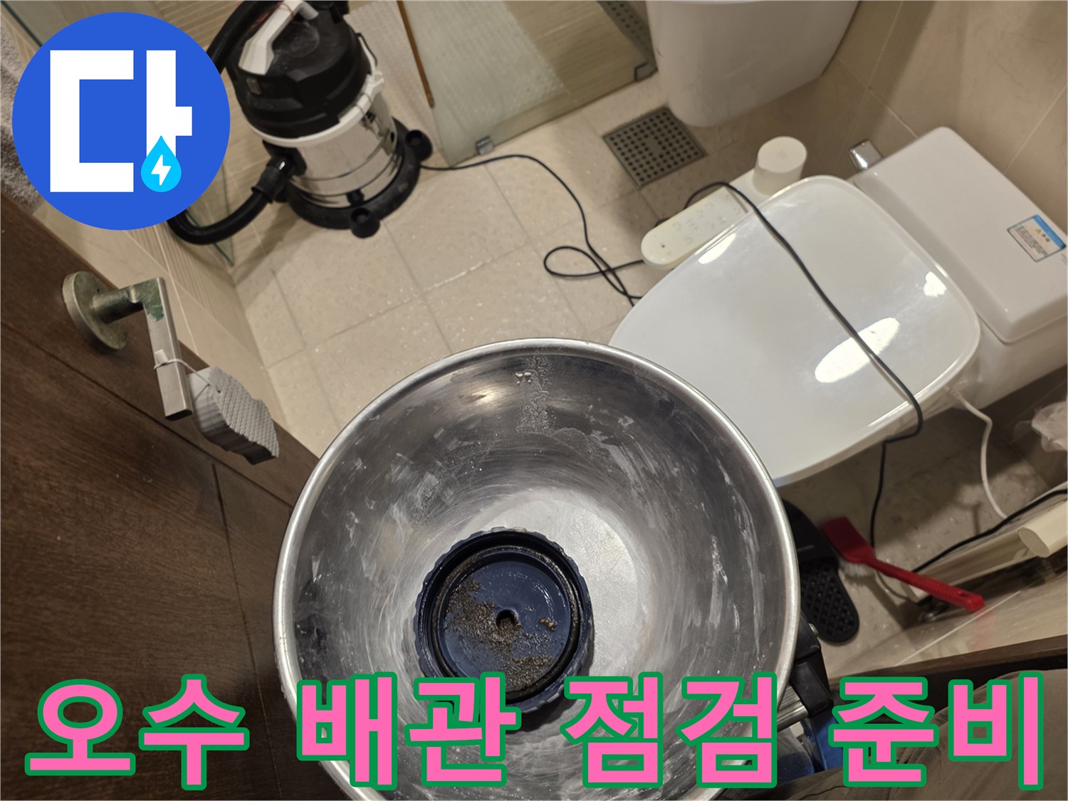화장실 바닥에 배치된 전문 석션 장비와 작업 도구들