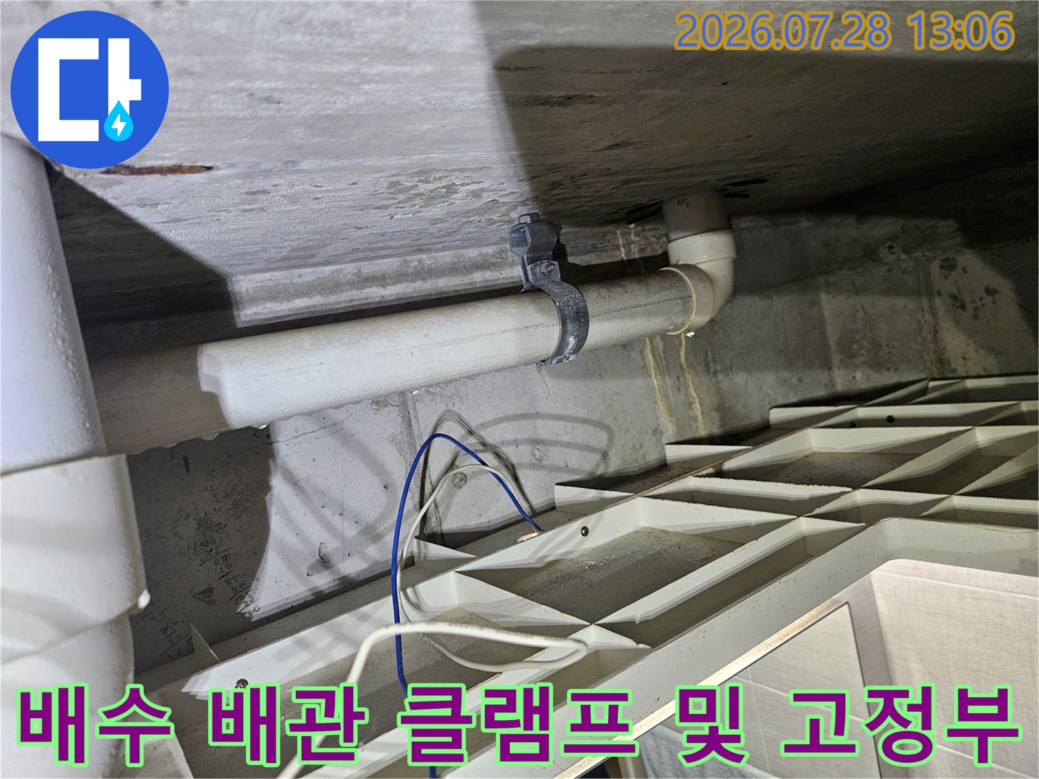 배수관을 지지하는 금속 클램프와 연결 부위의 노출된 구조물
