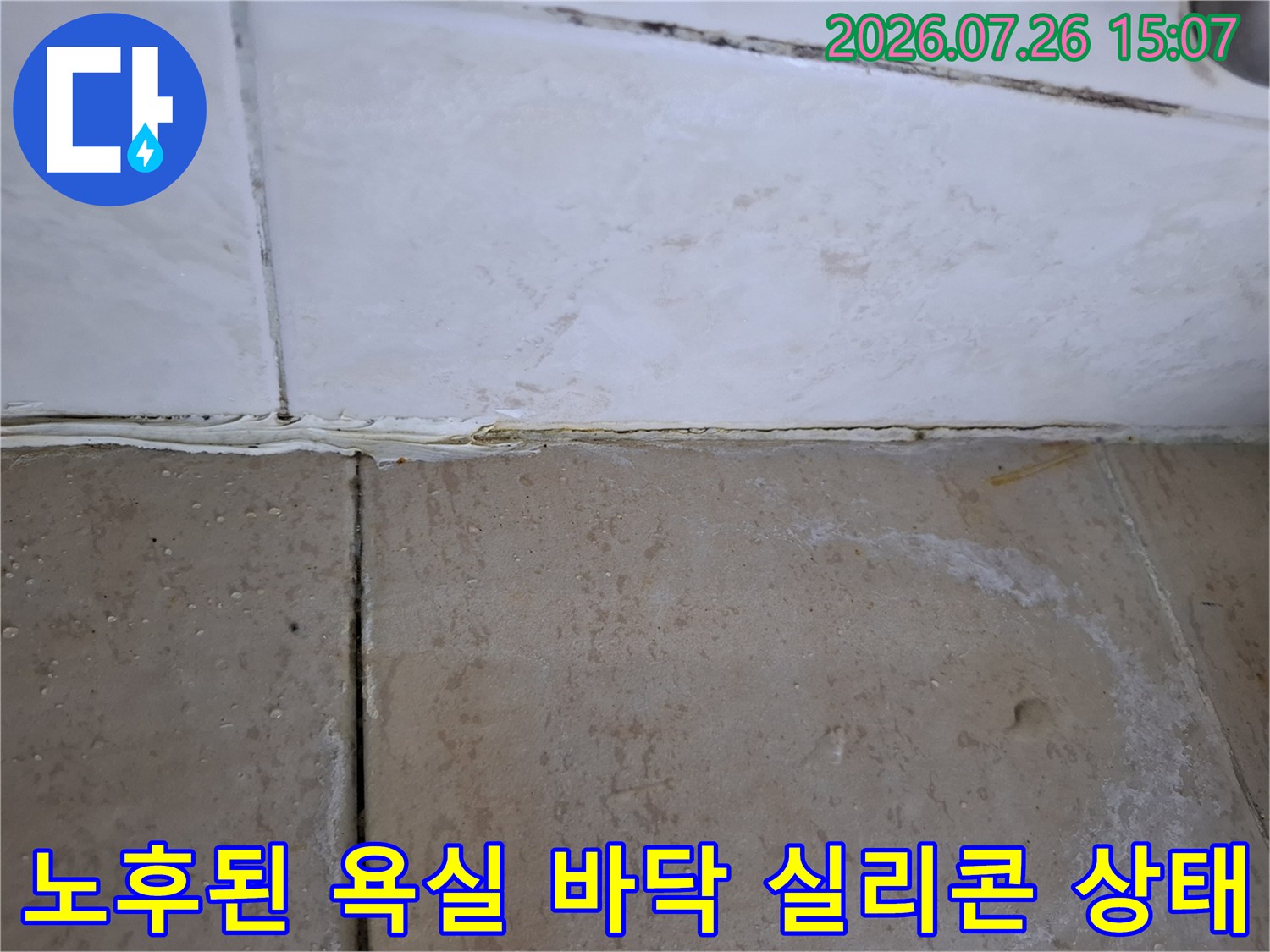 흰색 타일 사이의 줄눈과 마감재가 변색되고 틈이 벌어진 욕실 모서리 부분