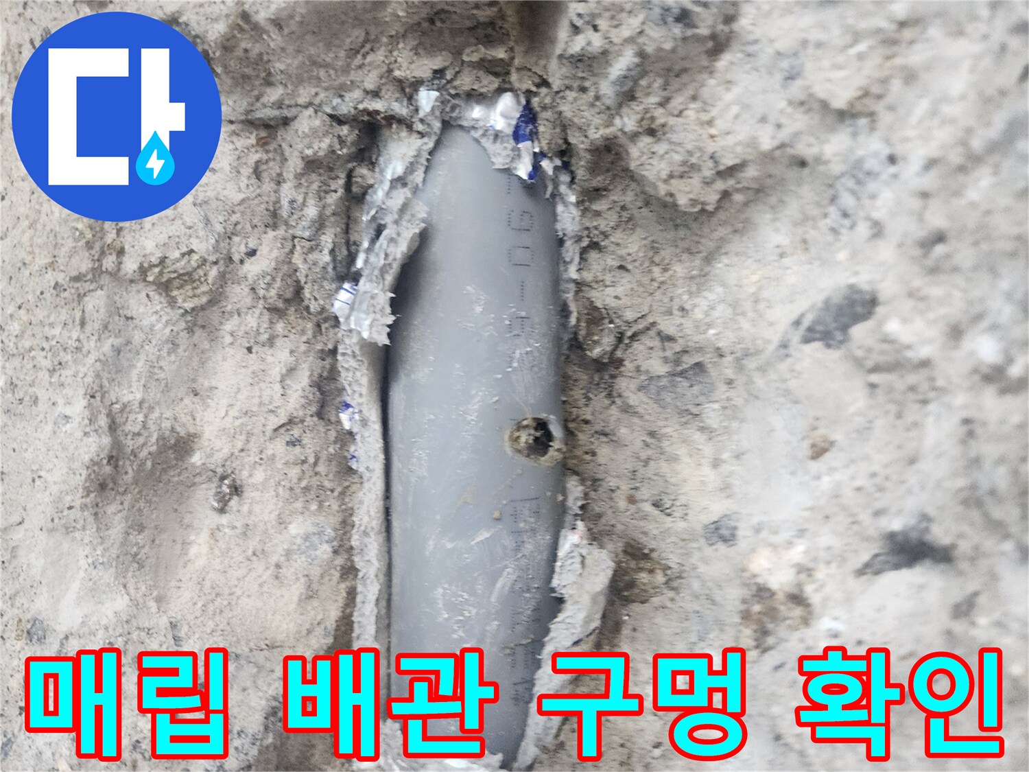 콘크리트 벽면 내부-노출된 회색 배관의 파손 부위