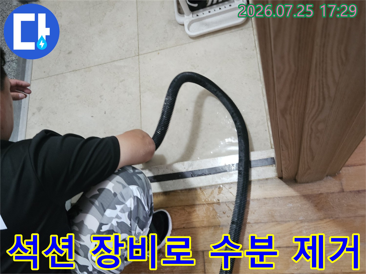 누수 지점의 물을 석션기로 흡입하여 주변 정리를 하는 공사 현장