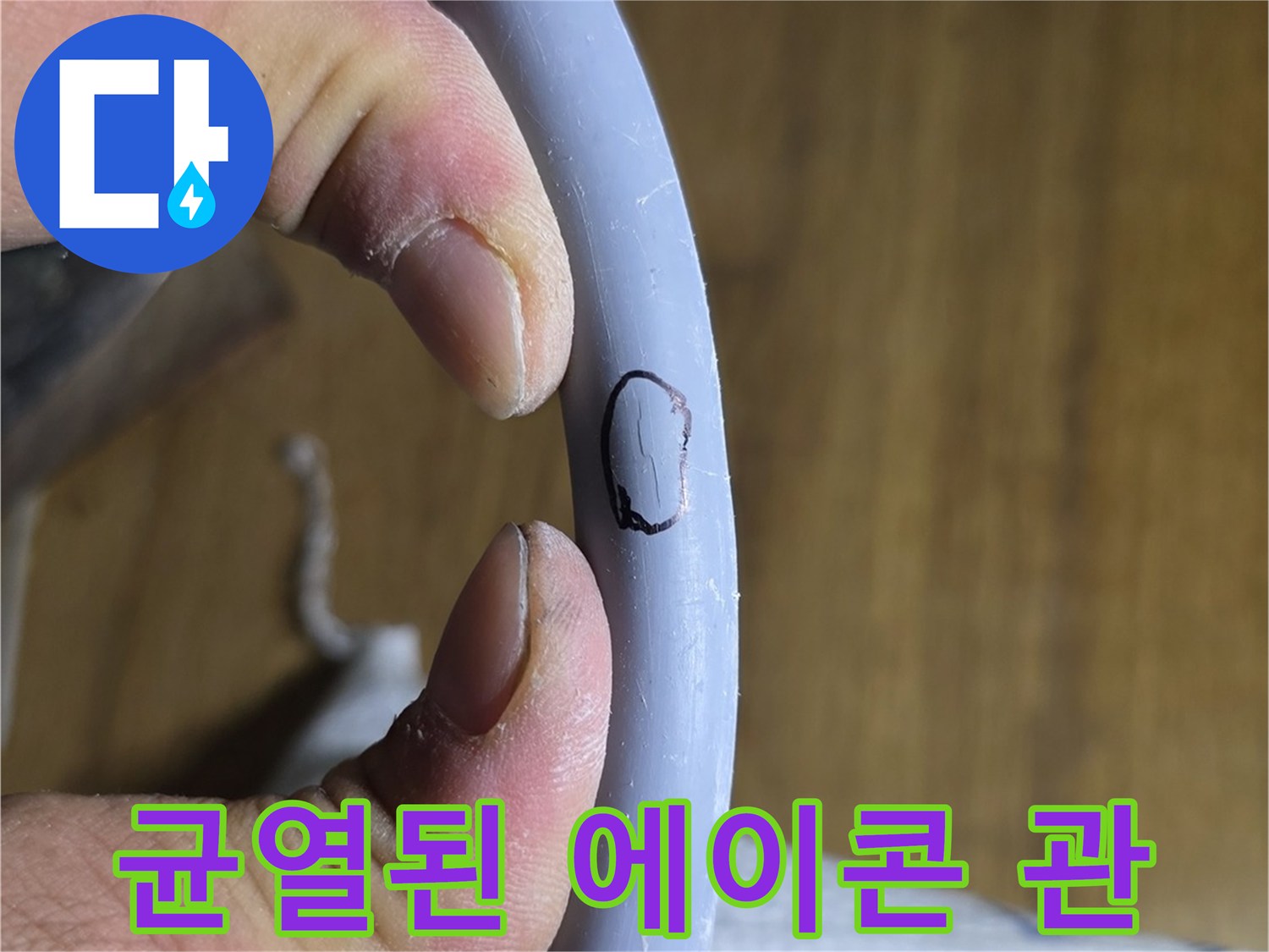 손으로 잡고 있는 회색 수도관의 파손 부위