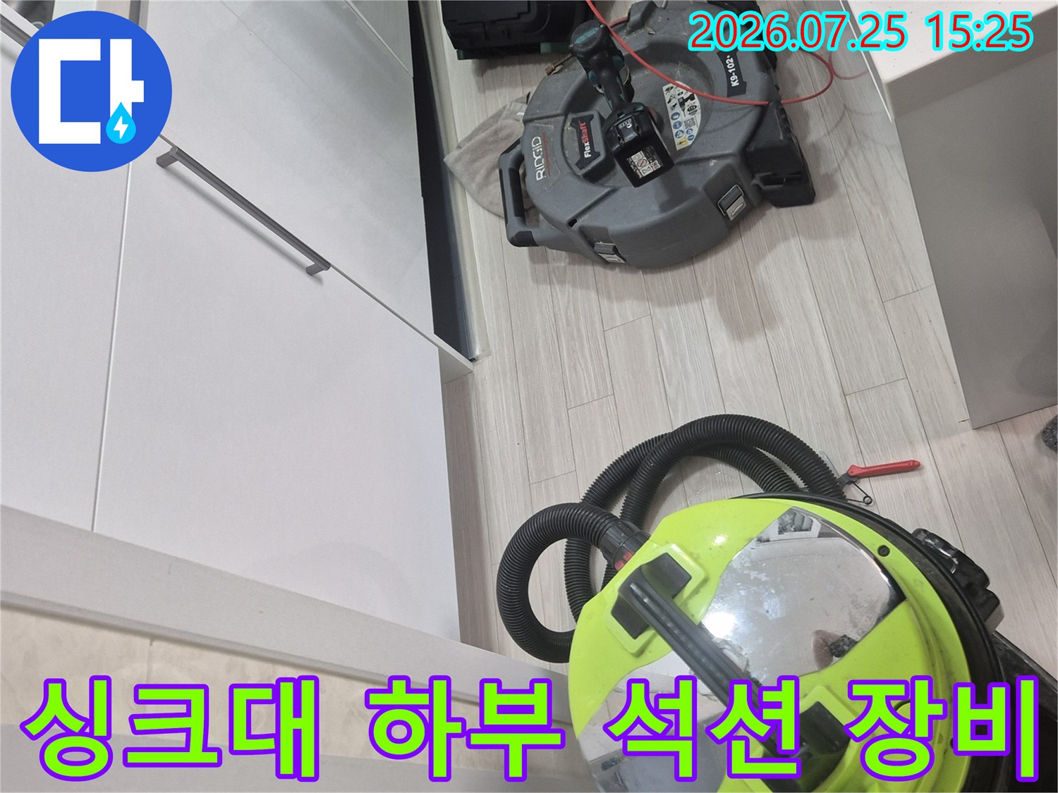 싱크대 하부 공간에서 배관 청소를 위한 강력한 석션 장비와 전문 공구 세팅