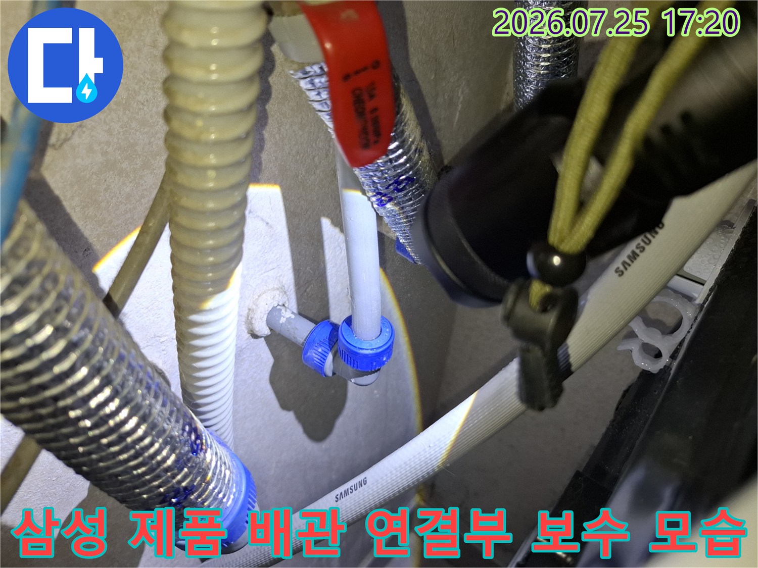 삼성 로고가 적힌 흰색 배관과 파란색 커넥터-빨간색 밸브 핸들이 보이는 누수 작업 현장