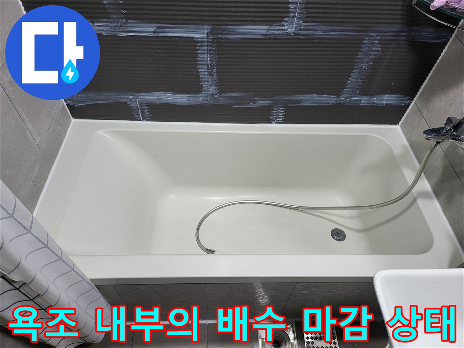배수구와 샤워기 호스가 연결된 욕조 모습
