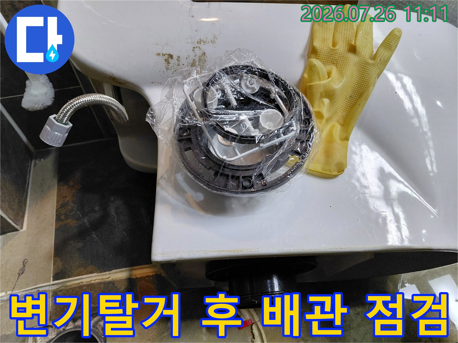 변기를 탈거한 후 노출된 하부 배수관과 앵글밸브를 점검하는 모습