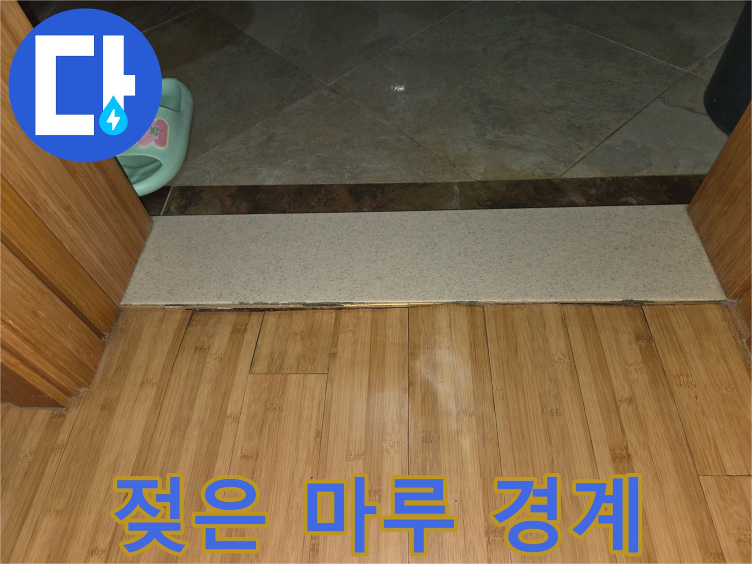 화장실 문턱을 따라 발생한 마루 변색 부위