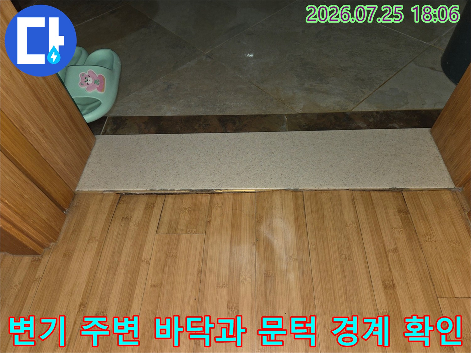 화장실 타일 마감과 나무 소재 문턱의 접점 촬영