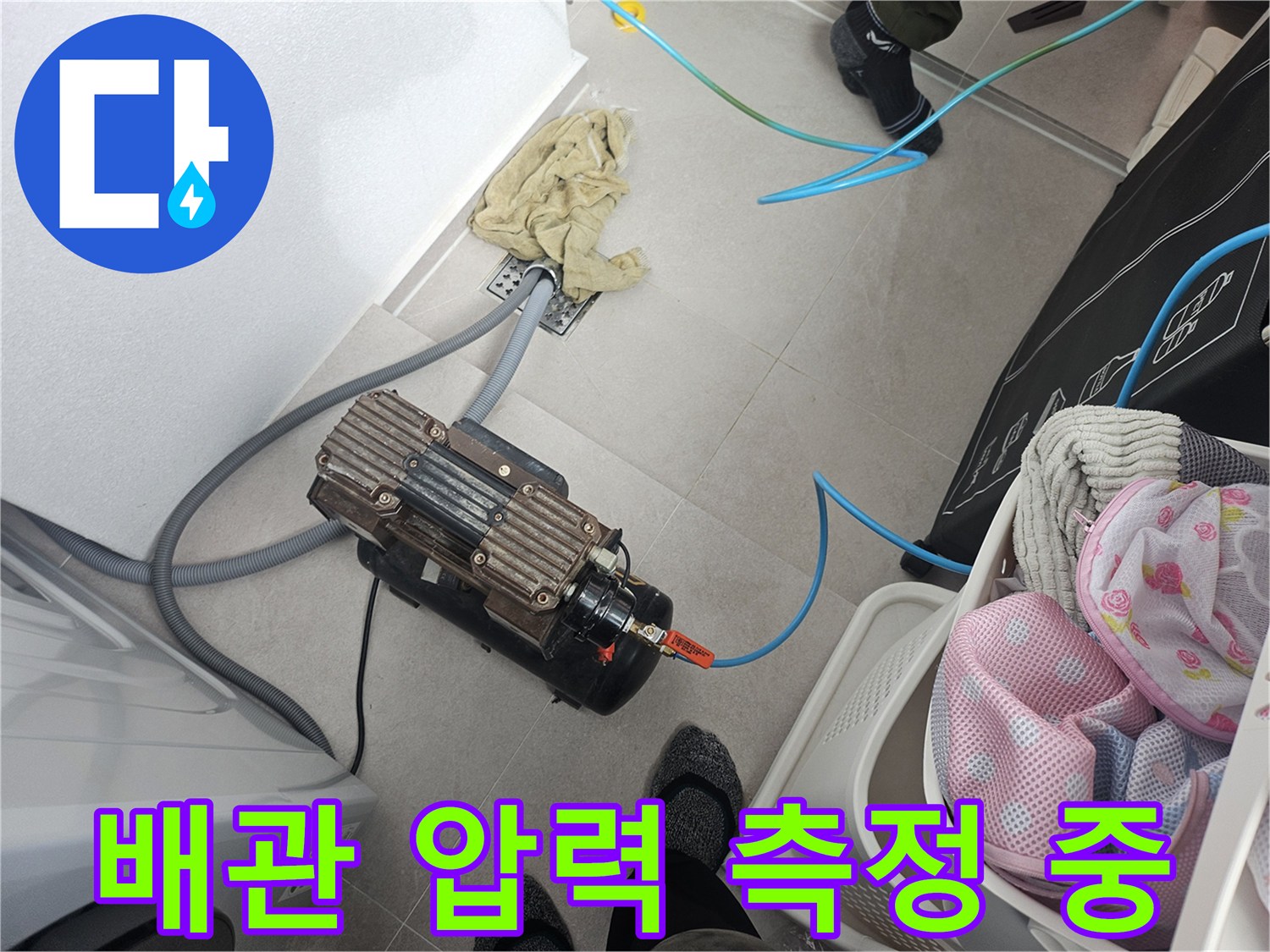 바닥 배관 연결 부위에 설치된 공기압 테스트 장비와 호스