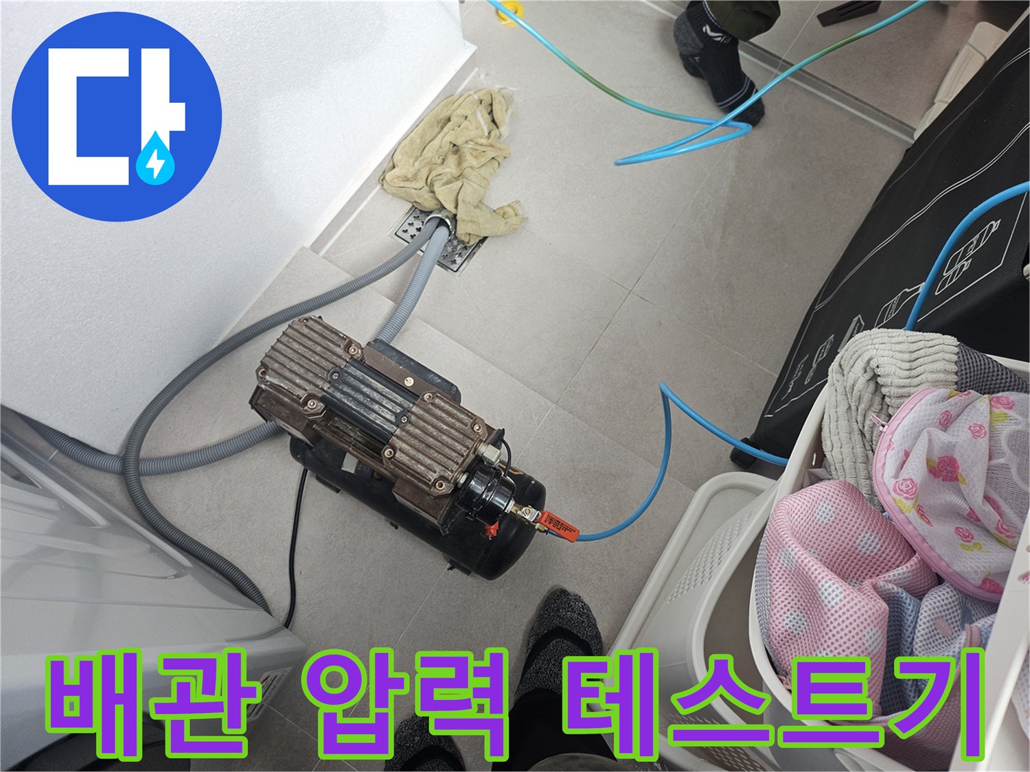바닥 배관 연결부에 연결된 공기압 측정 장치와 호스