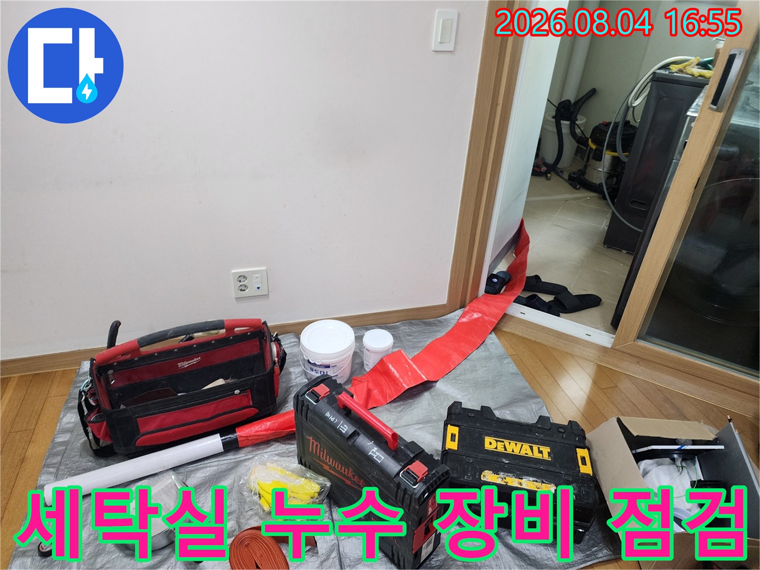 세탁실 바닥에 배치된 전문 누수 탐지 장비와 작업 도구들