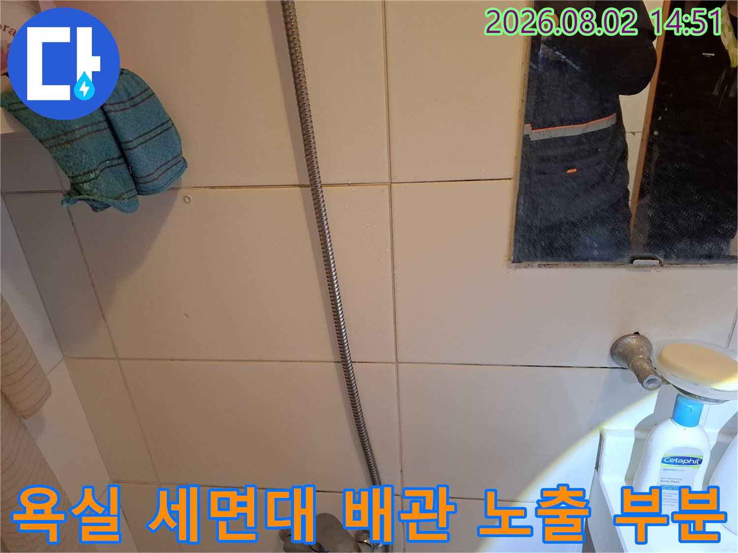 세면대 하부와 벽체 경계면의 배관 및 타일 상태를 촬영한 사진