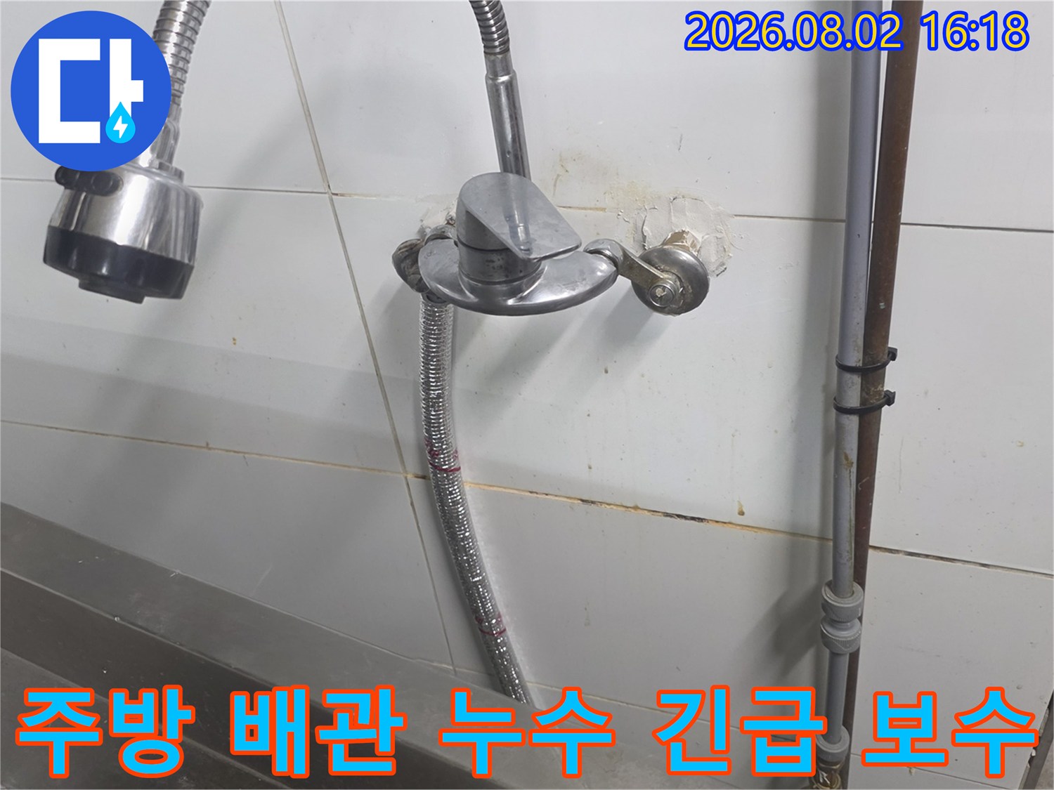상업용 주방 벽면에 노출된 수도 배관의 누수 지점 점검 현장