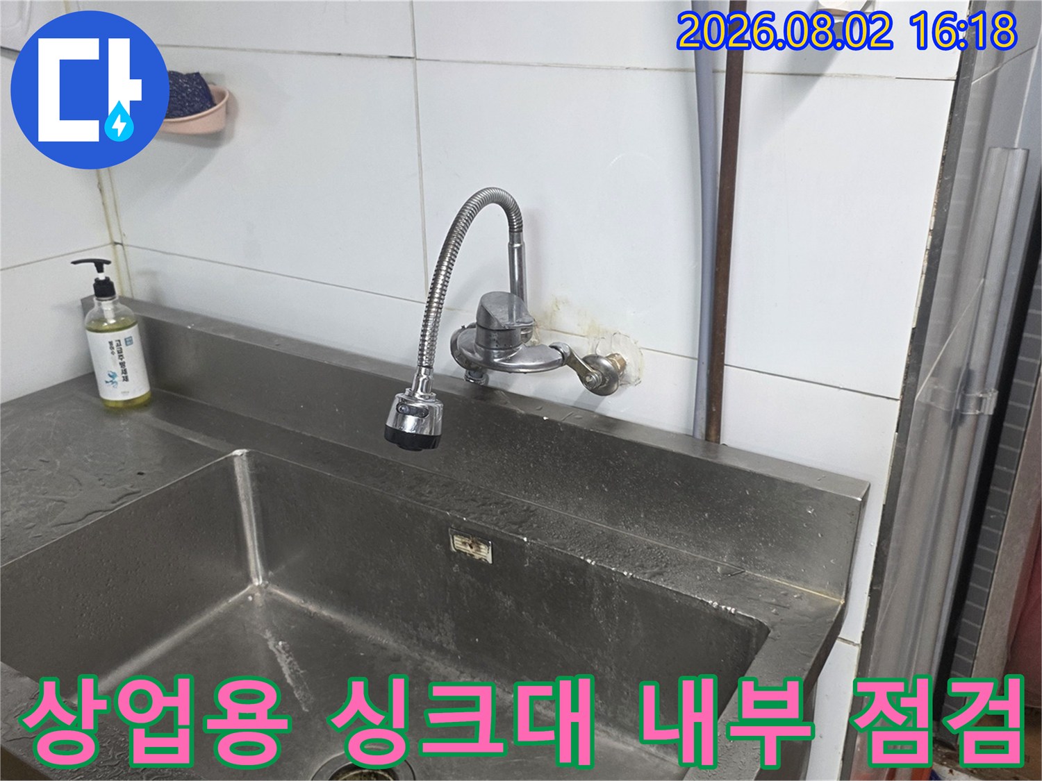 스테인리스 싱크대에 설치된 수도 수전과 배관 구조물 확인