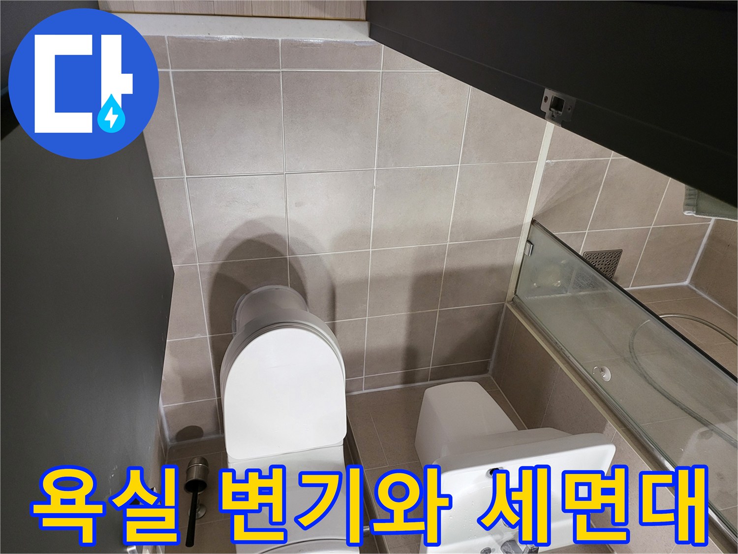 변기 주변 타일과 세면대가 설치된 화장실 내부 모습