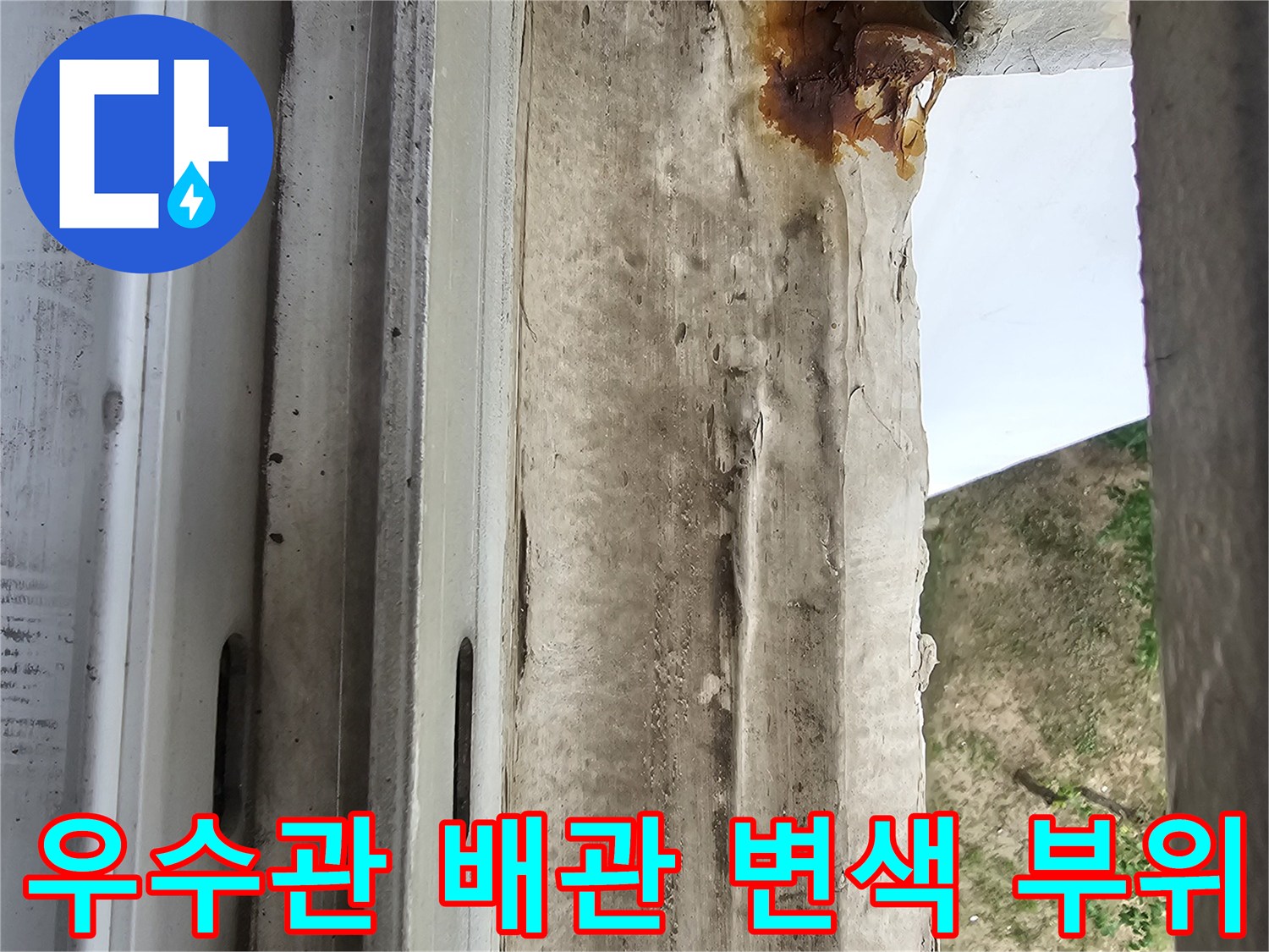 누수로 인해 붉게 변한 우수관 주변의 마감재와 틈새