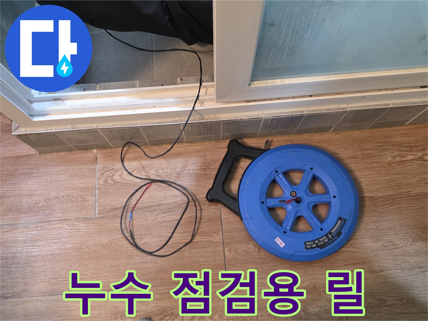 바닥 타일 위에 놓인 파란색 배관 탐지 장비와 호스