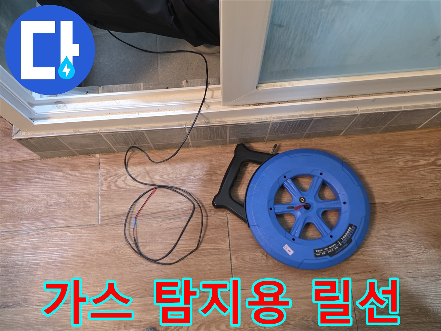 바닥에 펼쳐진 검사용 호스와 파란색 장비 릴