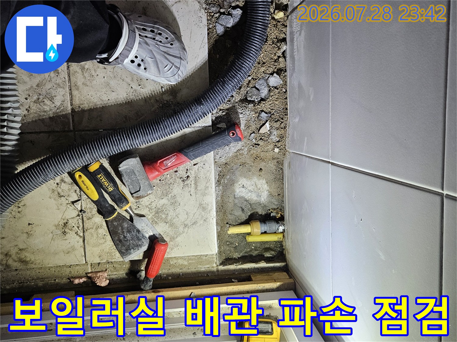노란색 가스 배관과 전동 공구 및 청소기 장비가 배치된 보일러실 바닥 작업 현장