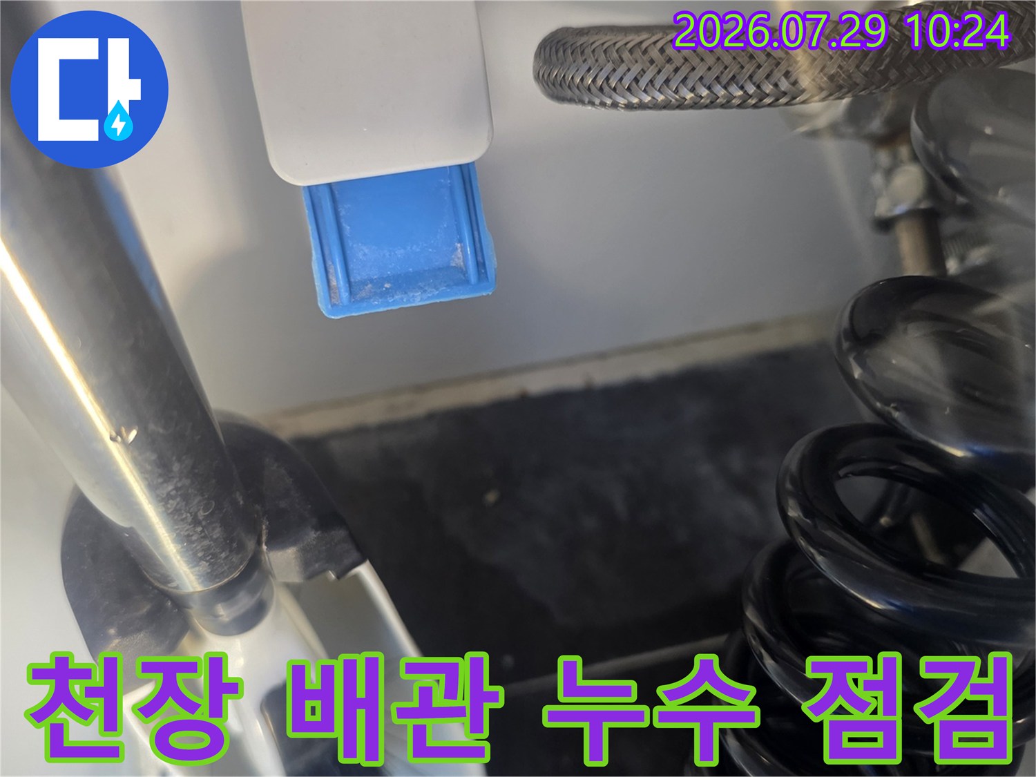 천장 안쪽의 노출된 은색 배관과 밸브 연결 부위를 세밀하게 관찰하는 모습