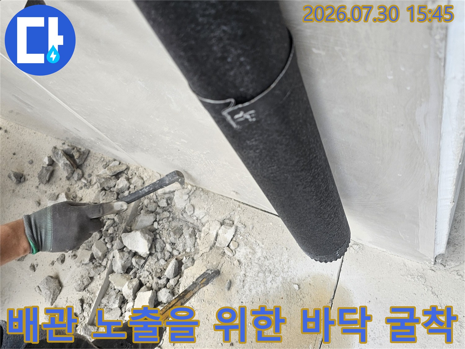 그라인더와 함마드릴을 사용하여 배관 누수 지점을 찾는 공사 현장