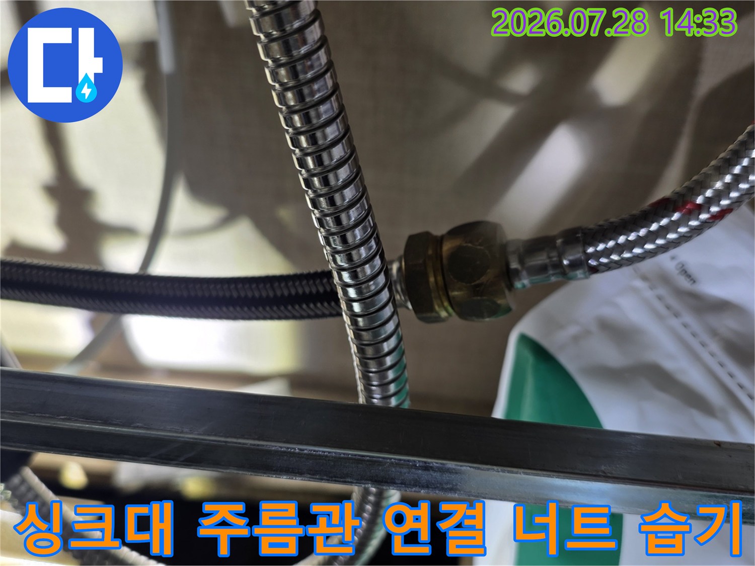 스테인리스 재질의 배관 연결 부위에서 물이 조금씩 새어 나오고 있는 장면