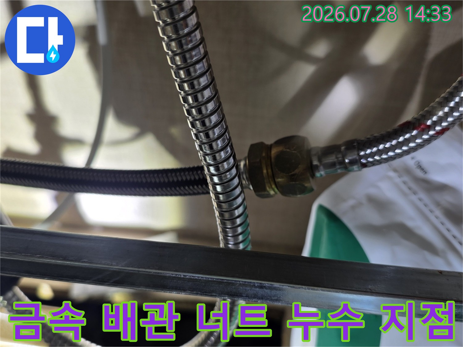 싱크대 하부의 금속제 주름관 연결 부위에서 물기가 맺혀 있는 상태를 촬영한 사진