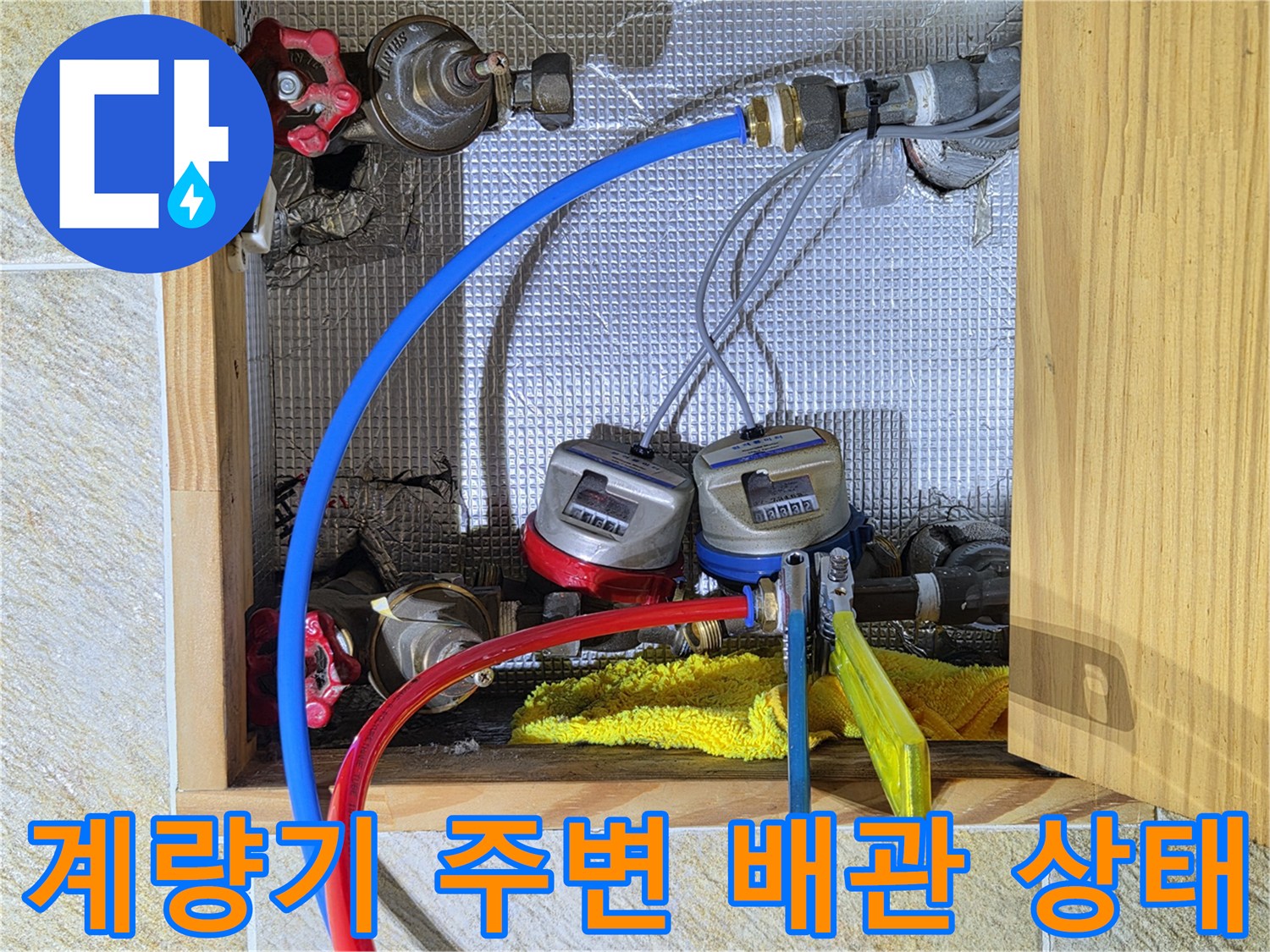 수도 계량기와 연결된 파란색 및 빨간색 호스와 밸브 부속품들