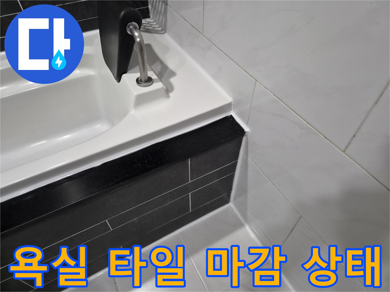 욕조-옆면-검은색-타일과-흰색-욕조-경계-부분