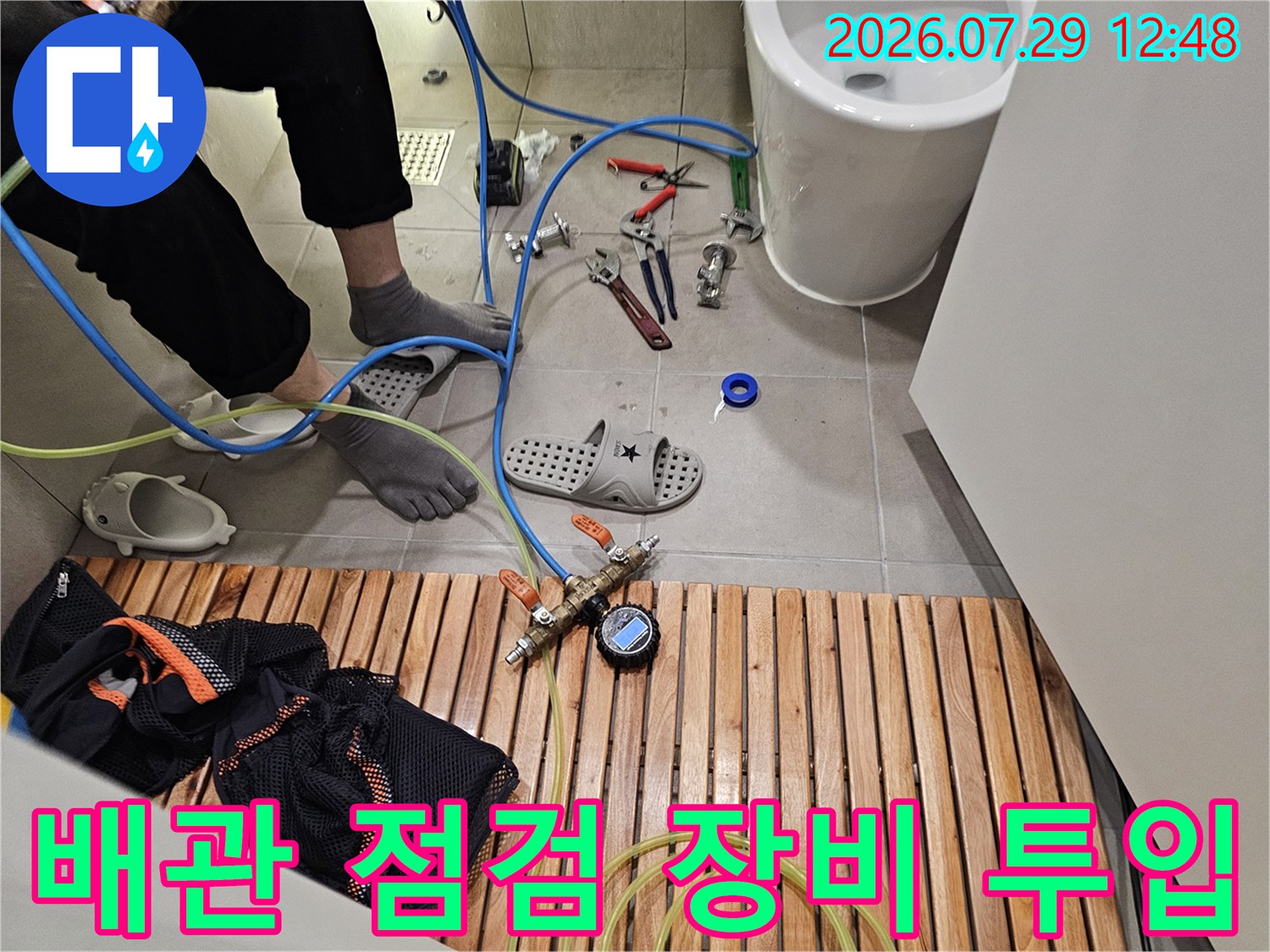 베란다 배관을 세밀하게 점검하는 전문 장비와 기술자의 모습