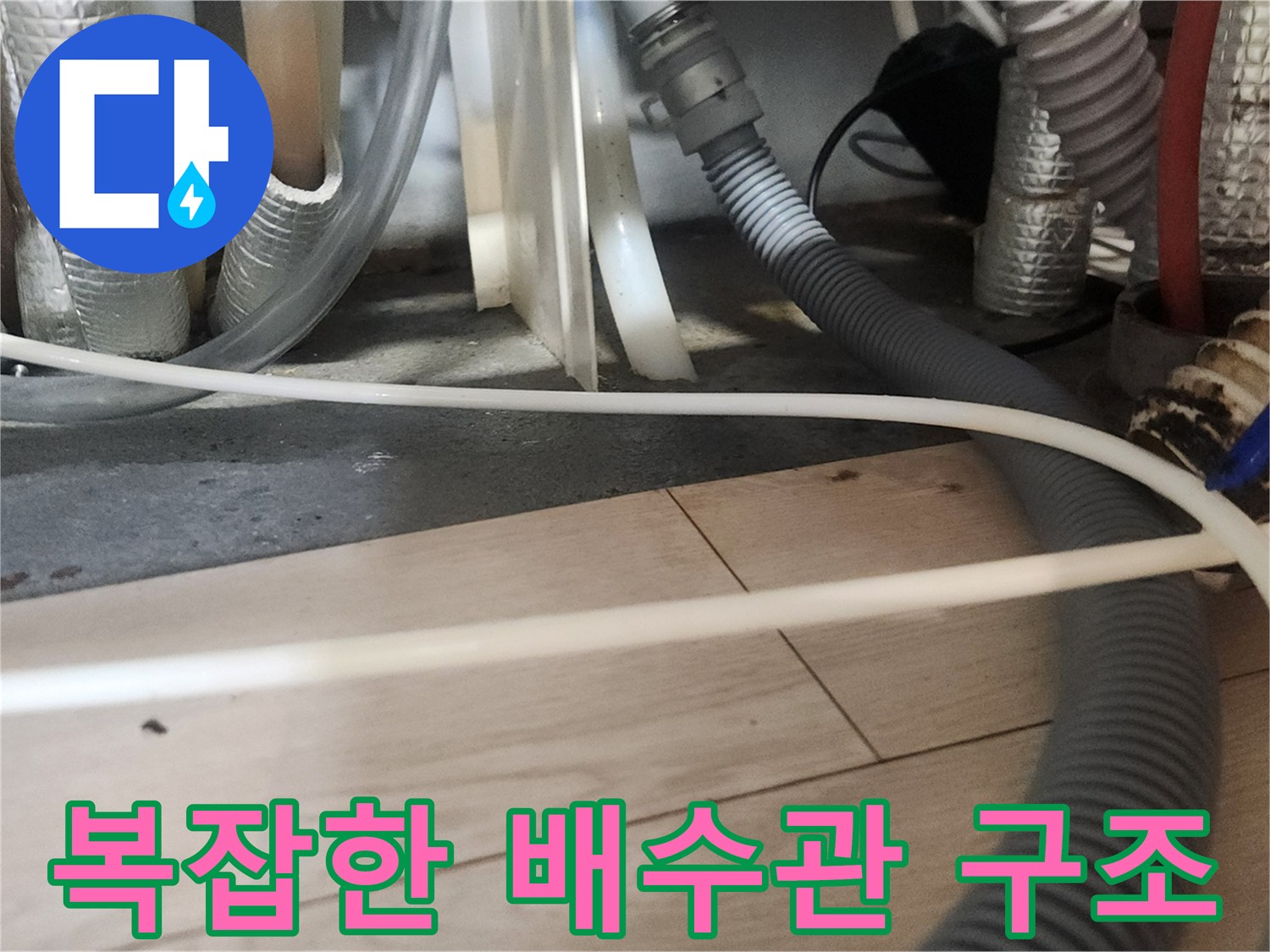 싱크대 아래 얽혀 있는 다양한 종류의 배수 호스들