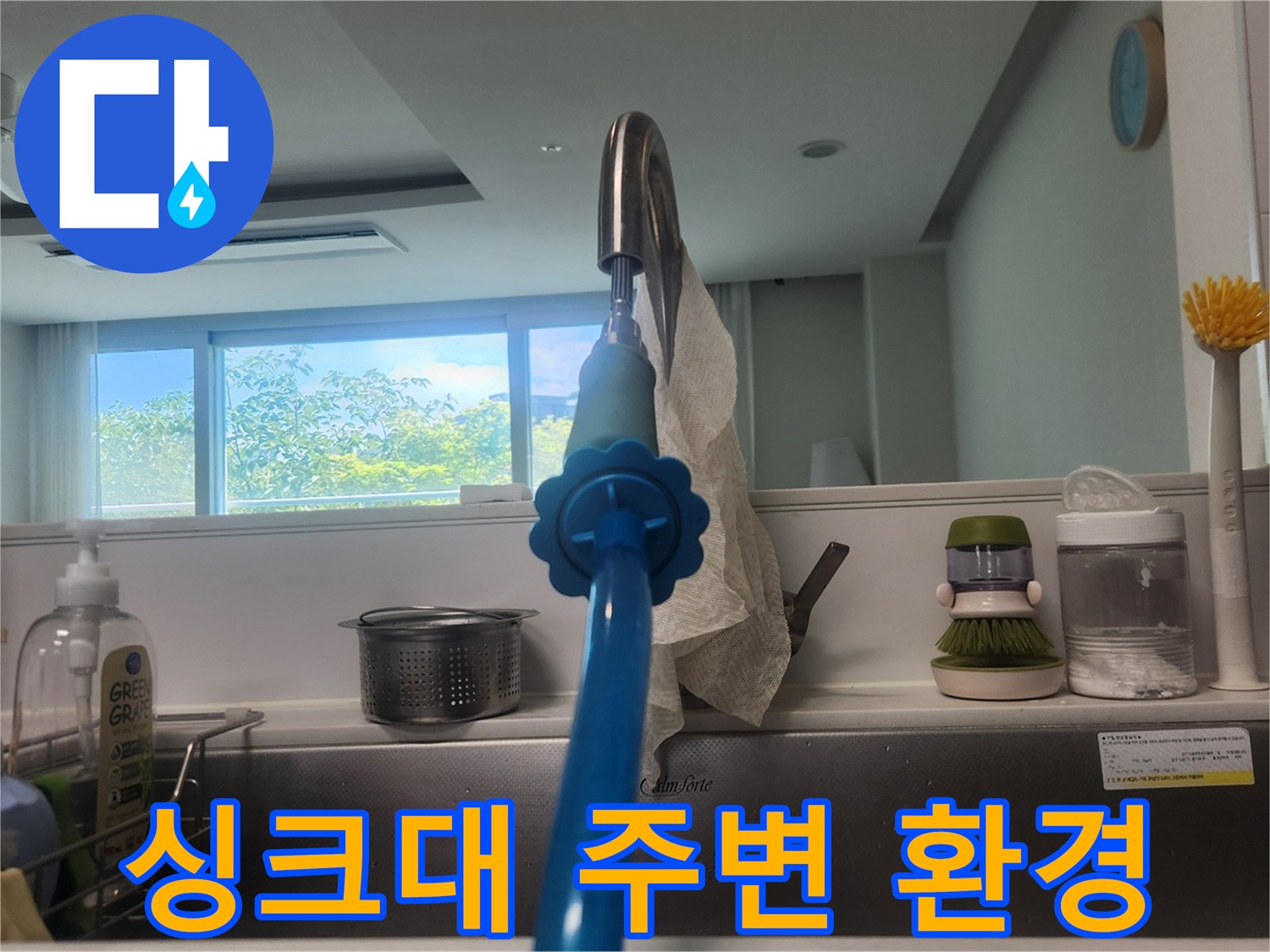 정돈된 모습의 주방 싱크대 수전과 세제통입니다.