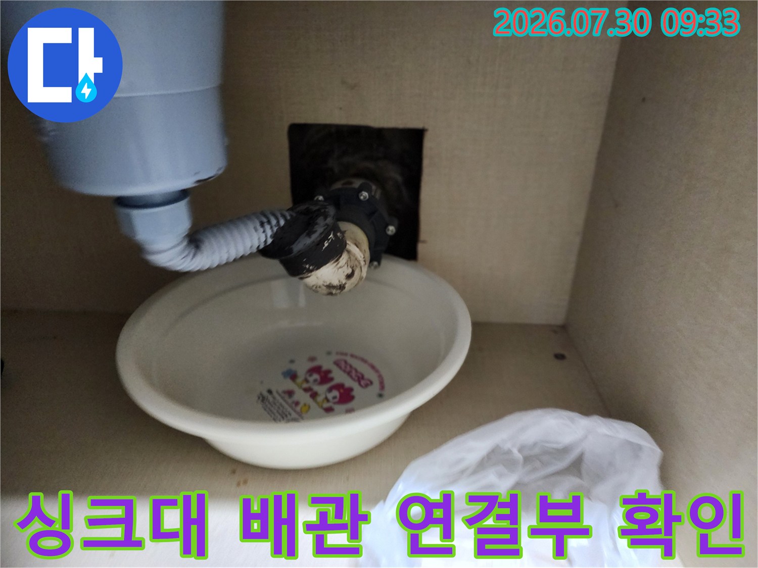 싱크대 하부의 노출된 배관과 바닥 배수구 연결 부위 점검 모습