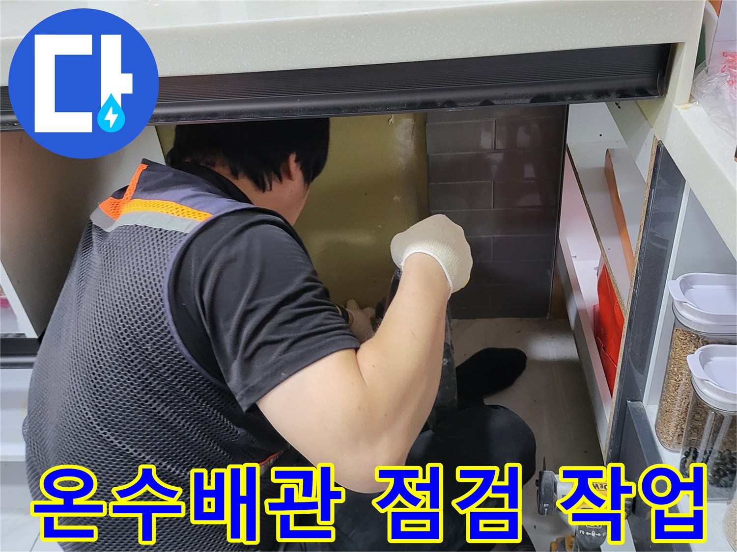 싱크대 아래 공간에서 배관의 누수 지점을 찾는 모습