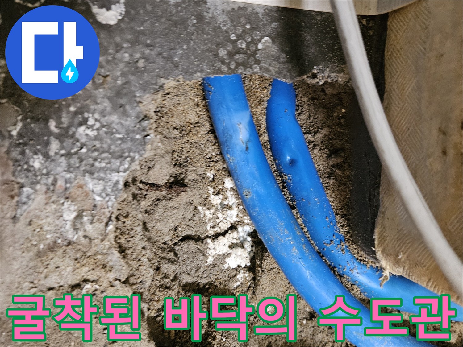 콘크리트 층을 파내어 노출시킨 손상된 파란색 배관