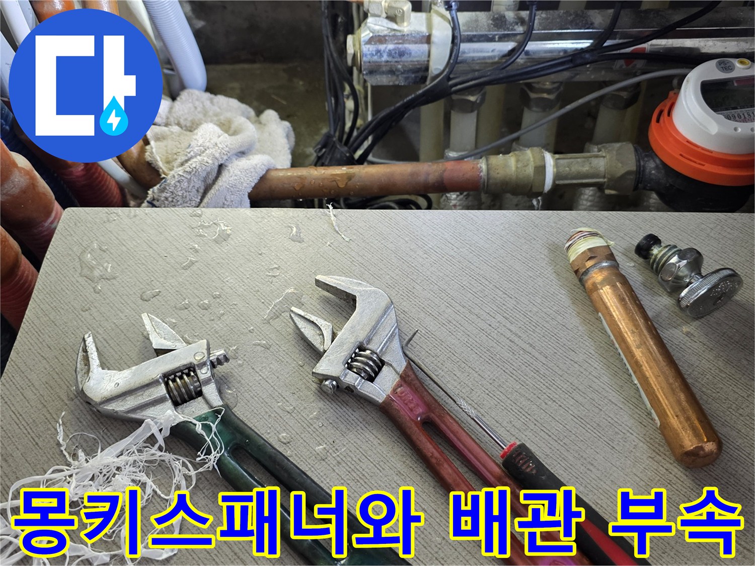 누수 수리 작업 중인 싱크대 아래의 공구와 자재들