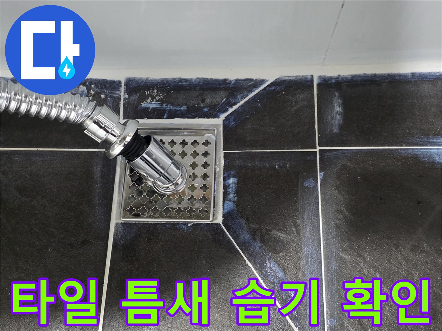 배수구 주변 타일 사이의 물기를 근접 촬영한 이미지입니다.
