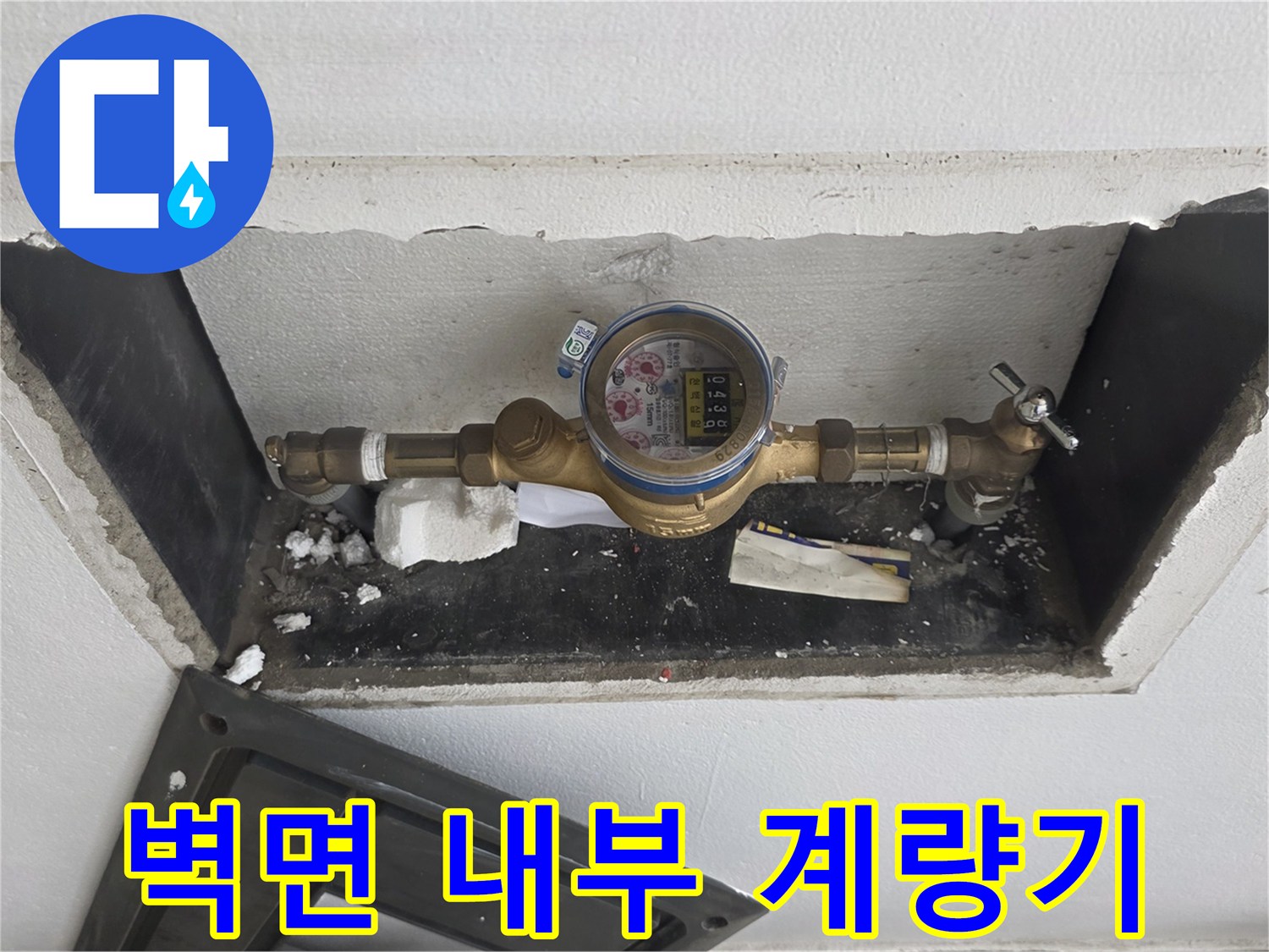 벽체 틈새로 보이는 수도 계량기와 금속 배관 연결부 상세