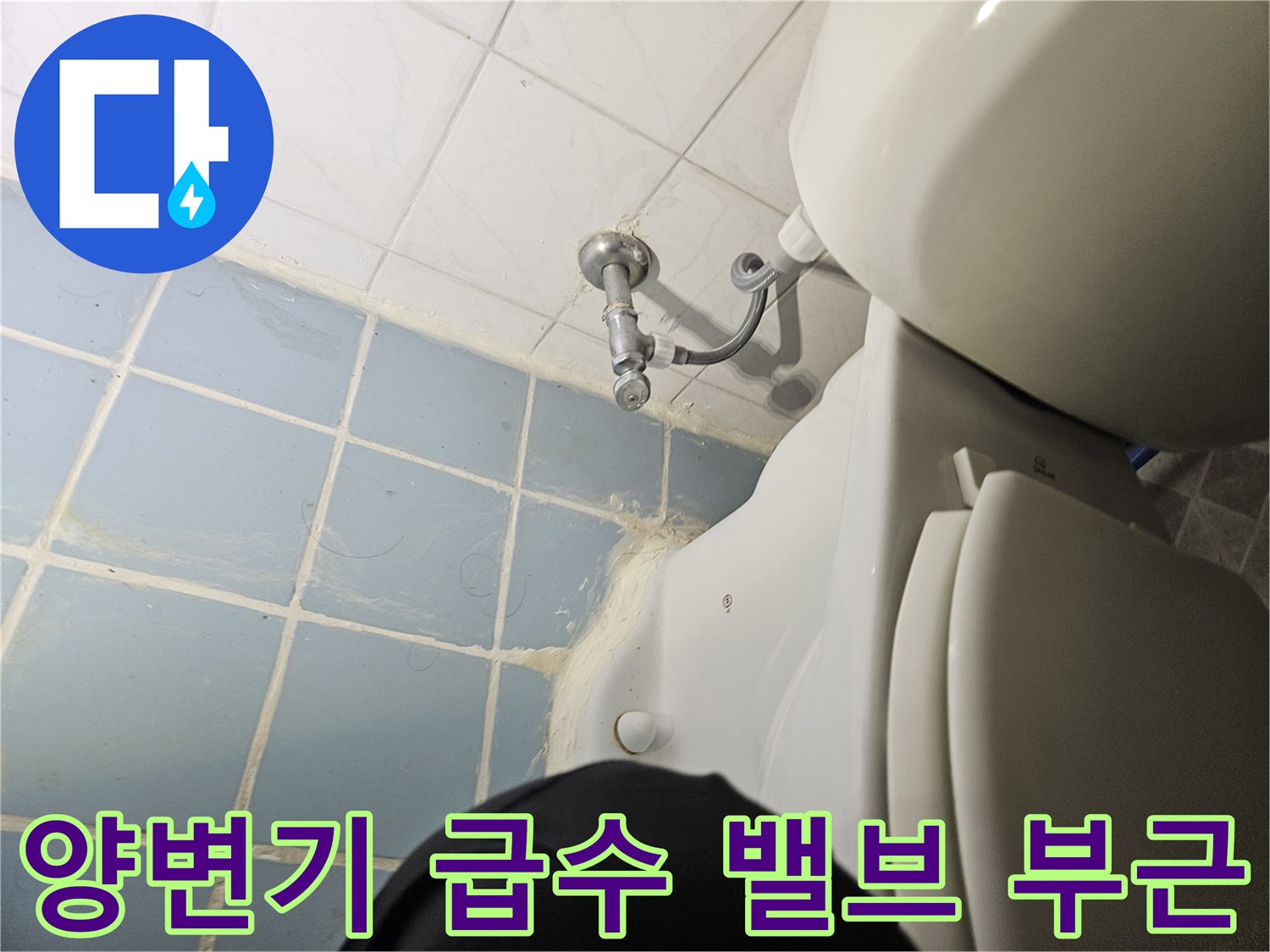 변기 옆에 위치한 은색 수도 꼭지와 타일 벽면 사진입니다.