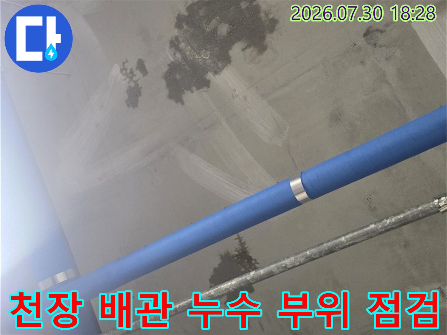 파란색 노출 파이프 주변 콘크리트 천장의 누수 얼룩들