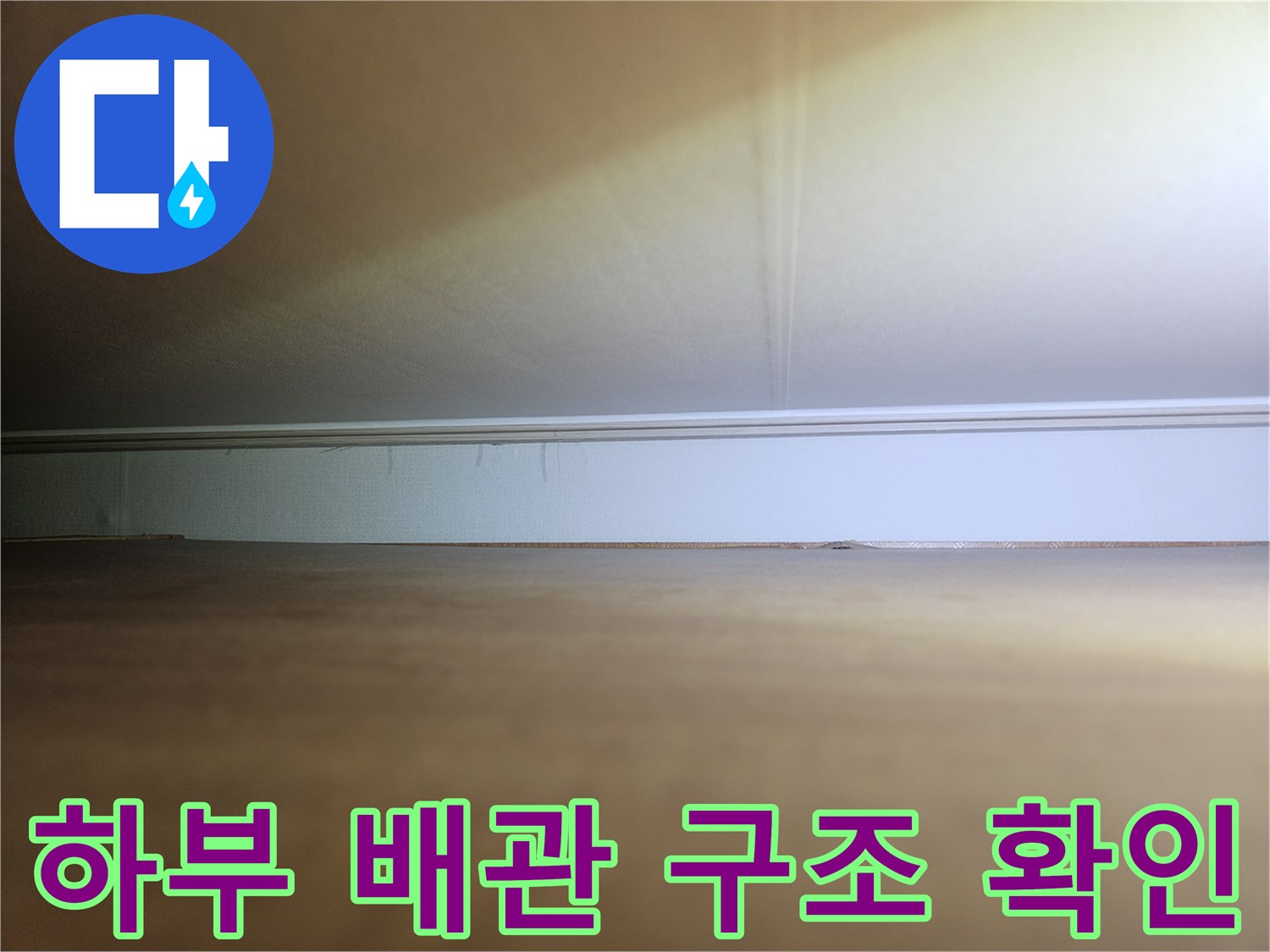 장롱 밑 좁은 공간 사이로 보이는 배관 연결 부위 상세 사진입니다.