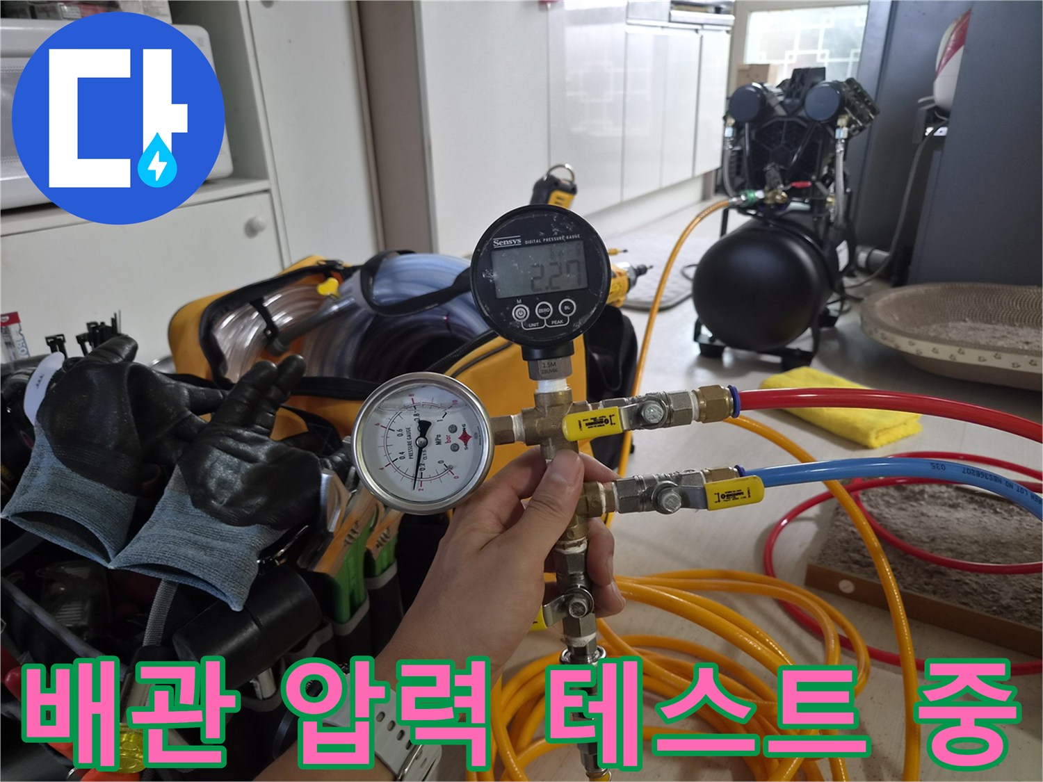 디지털-게이지와-연결된-호스를-사용한-배관-검사-장면