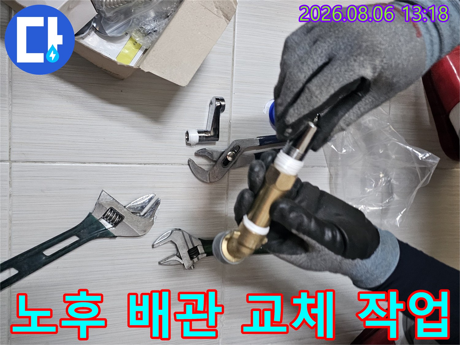 장갑을 낀 손으로 황동색 수전 연결 부품을 고정하는 모습