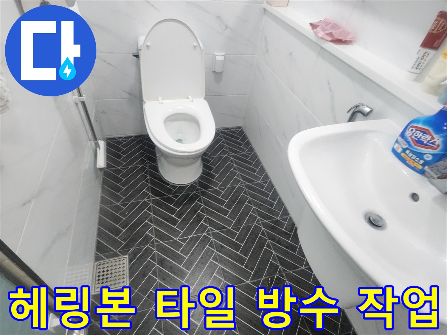 어두운색 헤링본 타일-변기 하단부 누수 점검 중