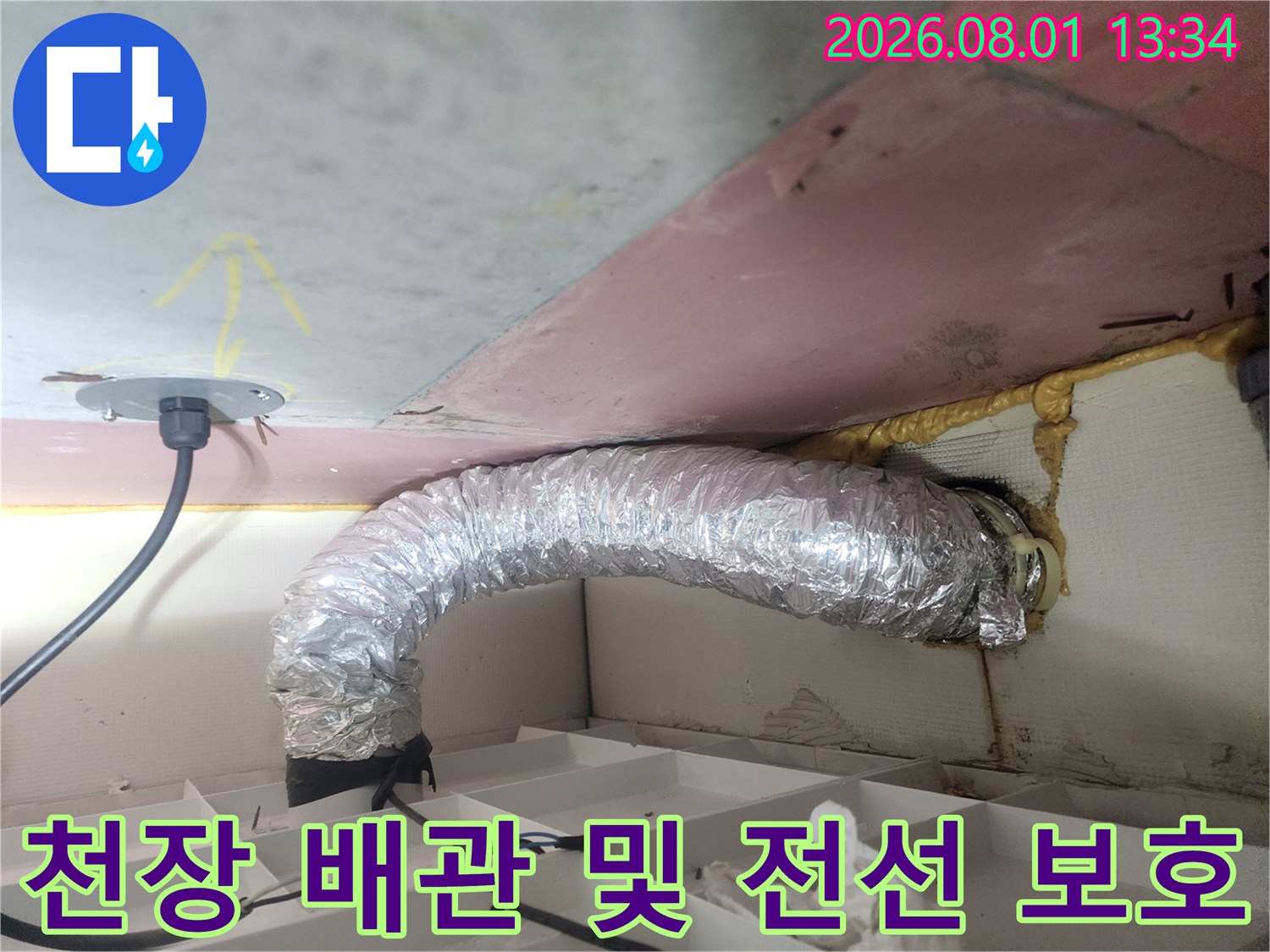 은색 단열재로 감싸진 천장 내 배관과 전기 시설의 모습