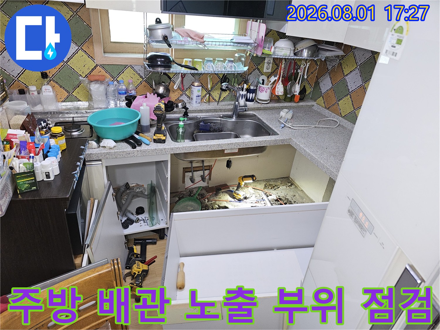 싱크대 밑 공간에서 여러 종류의 수전 및 급수 배관을 확인하는 장면