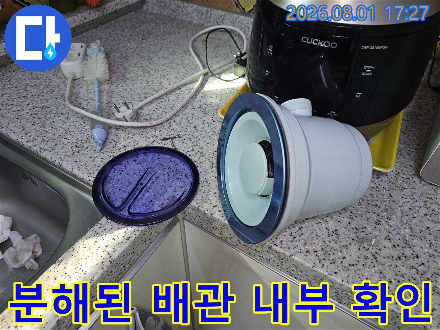 싱크대 아래 노출된 흰색 계열의 배관 구조물