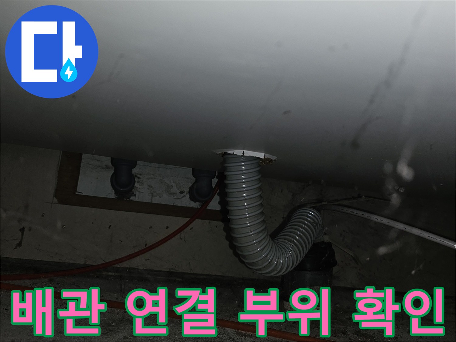 주방 싱크대 하단-벽면 배관과 연결된 회색 주름관의 모습