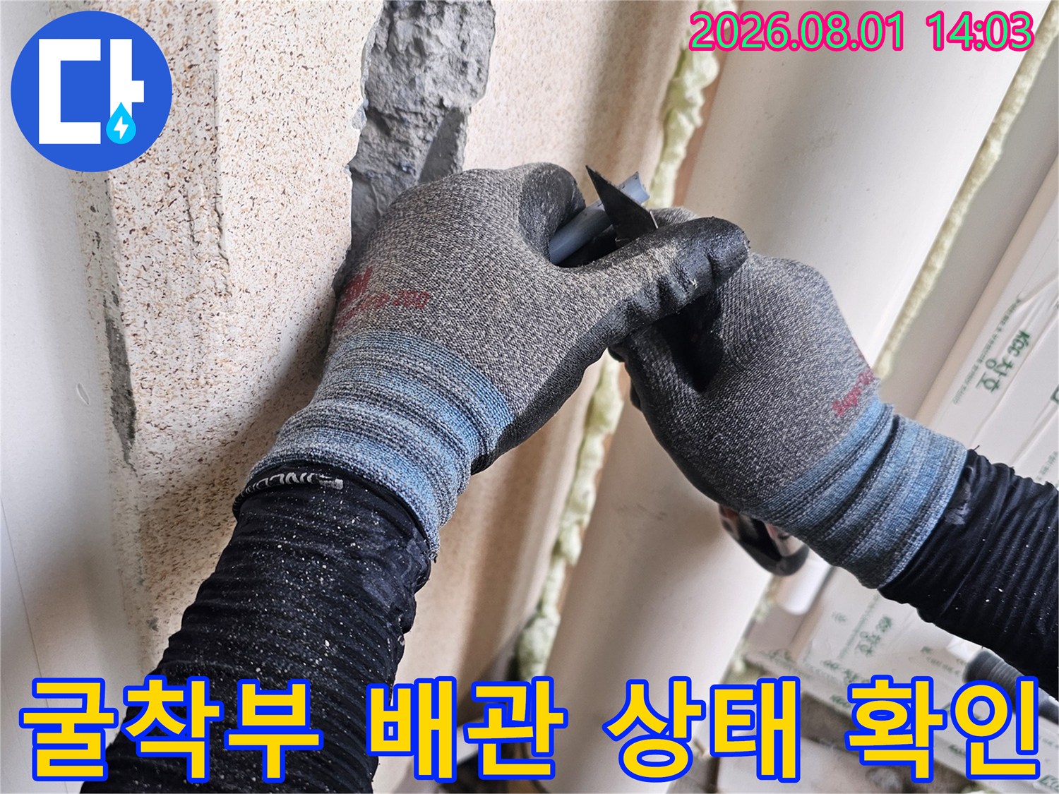 세탁실 타일 파쇄 후 노출된 직수 배관의 문제 부위를 점검하는 현장 사진