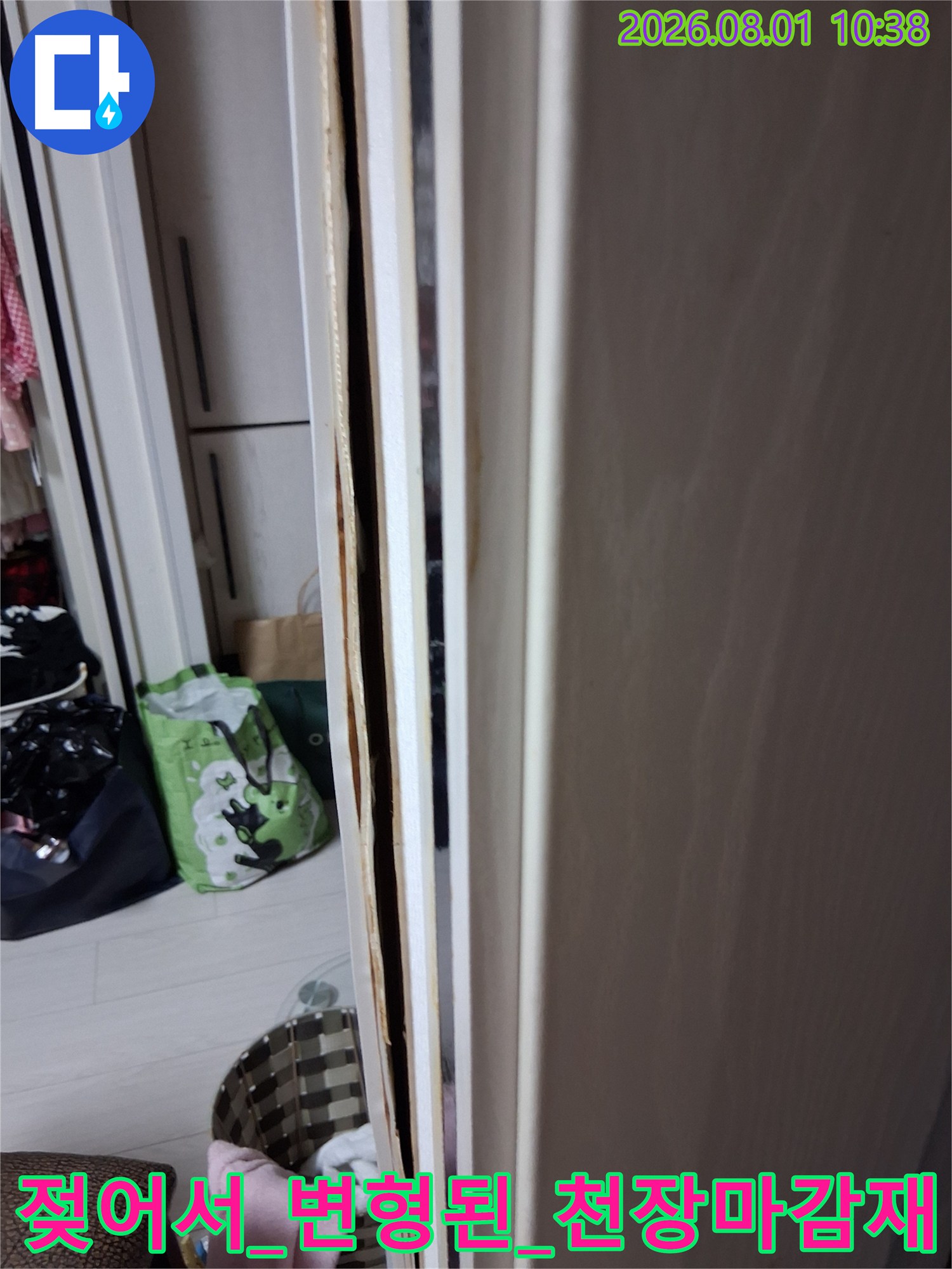 물에 젖어 변색되고 들뜬 화장실 입구 천장 마감재